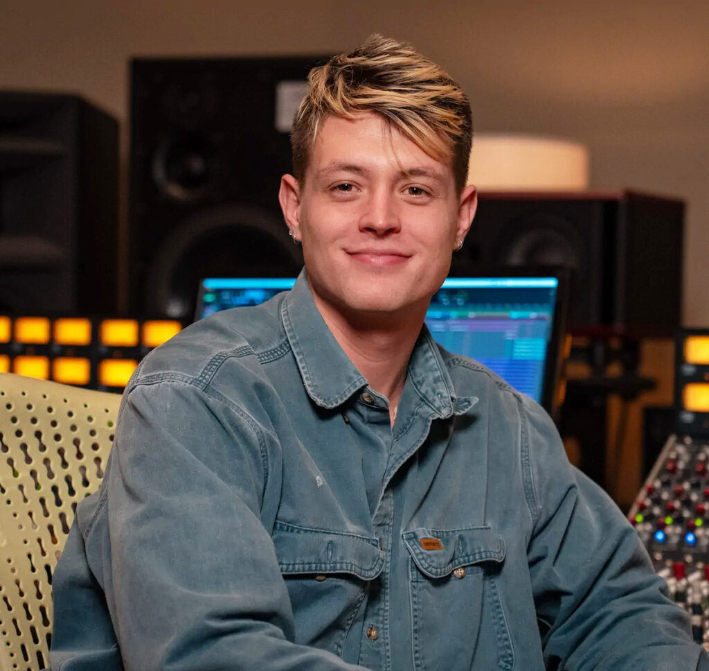 Jason Peets in a denim jacket smiling at the camera while.