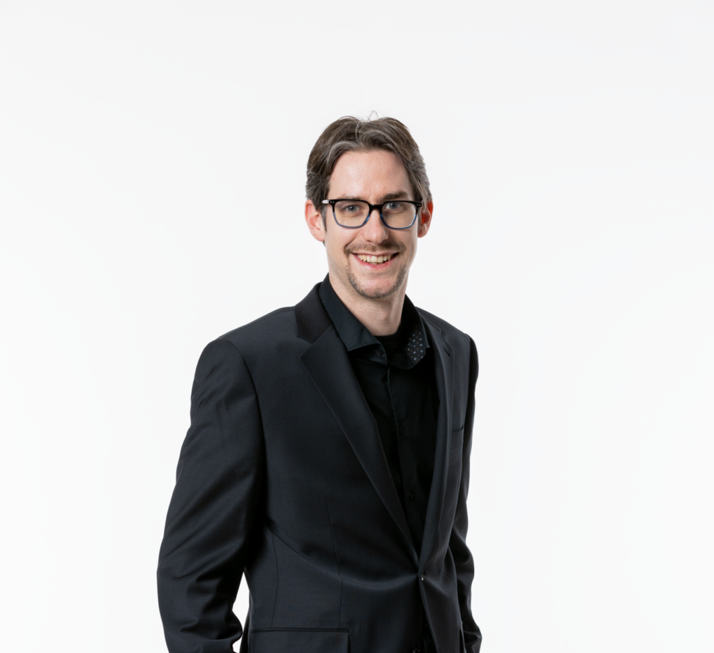 Casey Cooper in a suit smiling at the camera